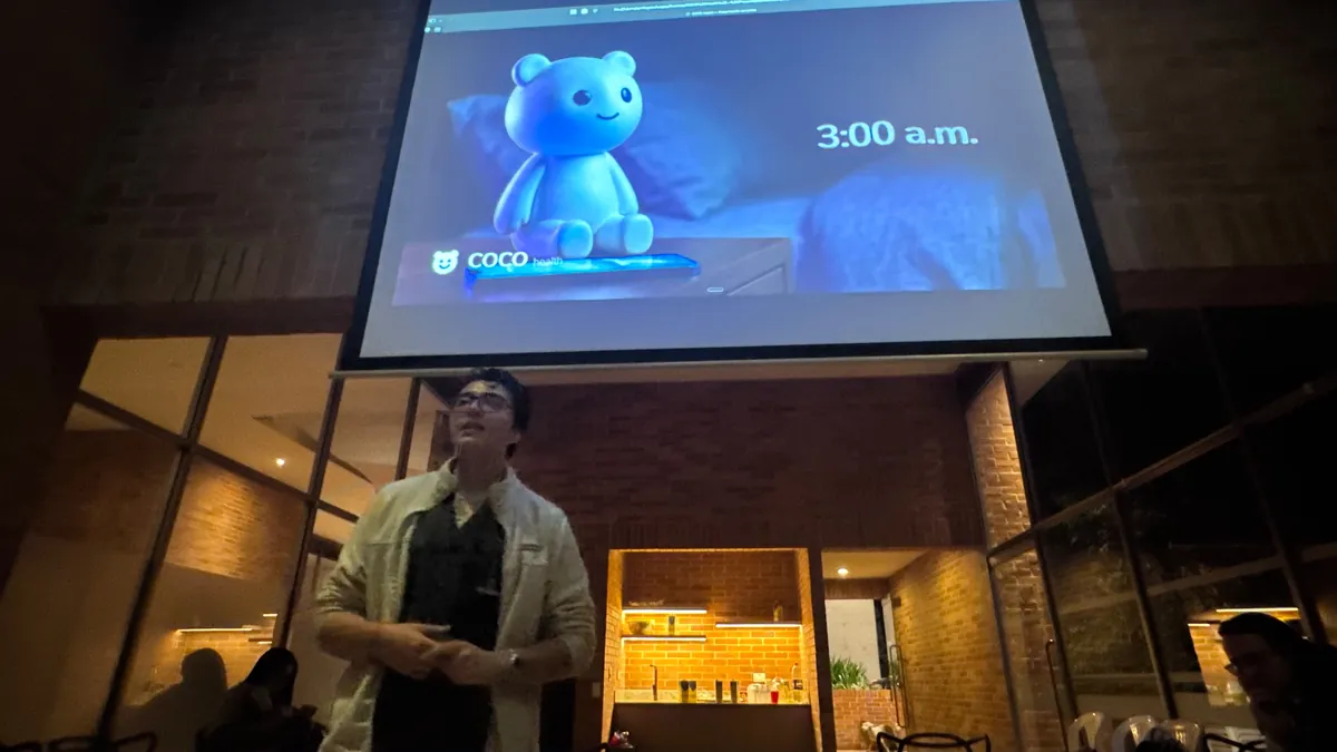 Charla de COCO en Tech Week, con el osito proyectado en pantalla a las 3:00 a. m.